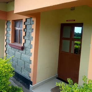 A building with a stone facade, a wooden door, and a window with a red ledge. - Petluck Resort Naivasha (Naivasha)