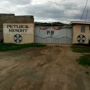 A gated entrance to Petluck Resort with a stone wall and a metal gate. - Petluck Resort Naivasha (Naivasha)