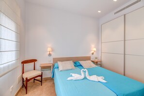 Une chambre à coucher comprenant un lit, deux tables de chevet, une chaise et une armoire.