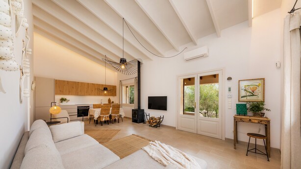 Uma sala de estar moderna com sofá, espaço de jantar e televisão.