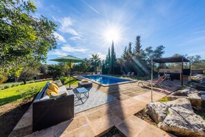 A backyard with a swimming pool, outdoor furniture, and a pergola. - Romantic Natural Stone Finca with Pool, Garden, Rooftop Terrace and Wi-Fi (Artá)