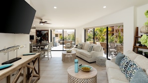 A modern living room with a sofa, coffee table, and dining area.
