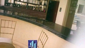 A lobby with a curved seating area, a bar with shelves of bottles, and a decorative wall. - Sun Paradise Nyali (Mombasa)