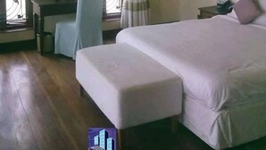 A bedroom with a bed, a desk, and a chair. There are windows with curtains. - Sun Paradise Nyali (Mombasa)