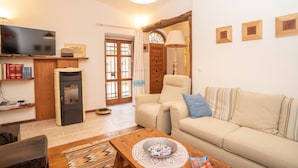 Una sala de estar con sofá, televisión, chimenea y puerta de madera.