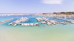 Un puerto deportivo con barcos amarrados, un muelle y una vista despejada de la costa.