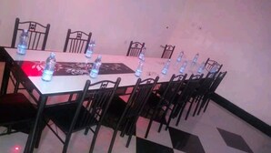 A conference room with a long table, black chairs, and water bottles on the table. - The Loop Guest House and Restaurant (Eldoret)