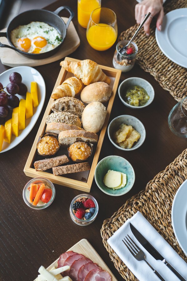 Una mesa con diferentes alimentos y bebidas para el desayuno.