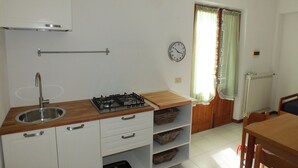A kitchen with a sink, stove, and cabinets.