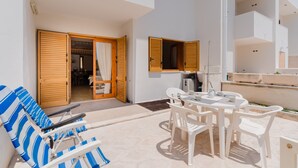A sunlit outdoor area with a pool, lounge chairs, and a dining table with chairs. - Holiday Home 'Casa Vacanze Cecilia A Otranto' with Sea View, Private Garden & AC (Otranto)