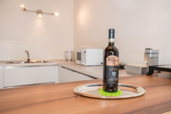 A bottle of Brunello di Montalcino wine on a glass tray in a modern kitchen with a microwave and a toaster.