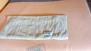 A bed with a towel and a pillow, a sign reading "WANJALA LODGE NAKURU" on the bedspread. - Wanjambi Lodge (Nakuru)