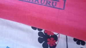 A red fabric with the text "WANJAMBI LODGE NAKURU" printed on it. - Wanjambi Lodge (Nakuru)