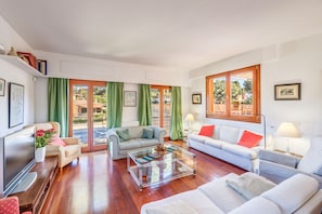 A spacious living room with a sofa, a coffee table, and a TV.