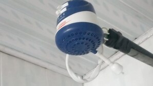 A blue and white water dispenser mounted on a white wall with a white ceiling. - Wasafiri Guest House (Nakuru)