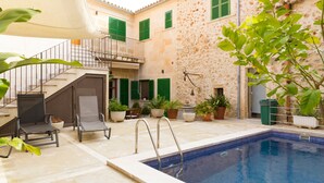 A pool area with a stone wall, a staircase, and outdoor seating. - Luxury town house with pool - Casa Pina (Pina)