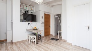 A modern kitchen with a built-in TV, a dining area with a table and chairs, and a staircase leading to another level. - Holiday Apartment "Atico Casapueblo" Near the Beach with Mountain View (Corralejo)
