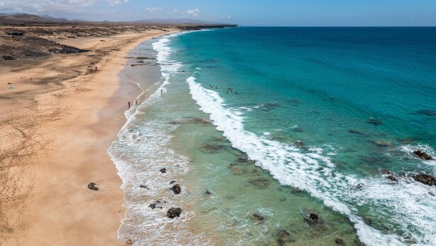 A coastal landscape with a beach, clear waters, and distant mountains. - Holiday Apartment "Atico Casapueblo" Near the Beach with Mountain View (Corralejo)