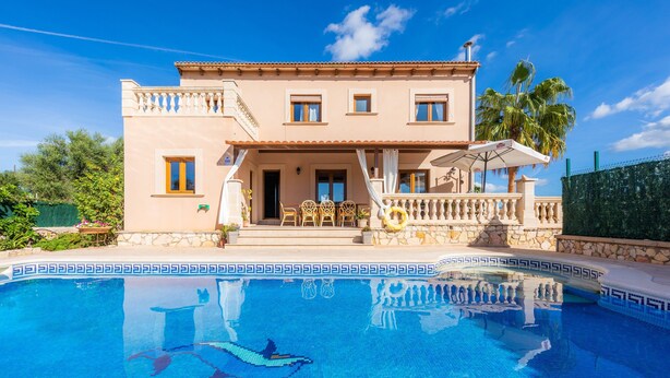 Un bâtiment à deux étages avec une piscine devant.