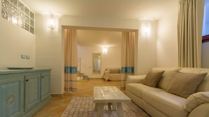 A living room with a sofa, a coffee table, a cabinet, and a patterned rug. - Stunning Villa Sabbia D'Oro with Wi-Fi, Terrace & Pool (Domus de Maria)