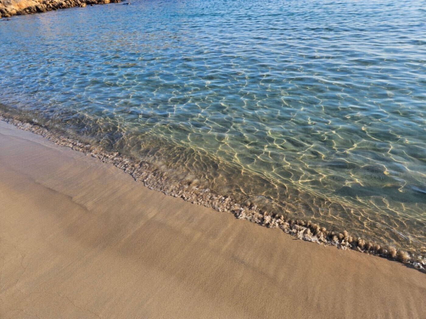 Ein Strand mit klarem Wasser und einem Sandstrand.