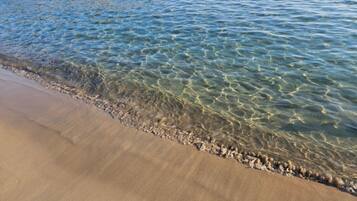 Ein Strand mit klarem Wasser und einem Sandstrand.