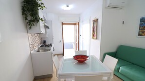 Une cuisine compacte avec une table à manger, des chaises et un canapé vert.