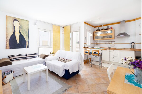 A modern apartment with a living area, a kitchen, and a dining space.