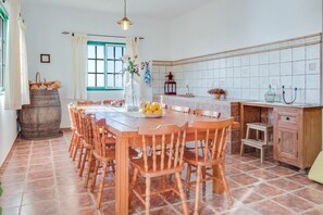 A dining area with a wooden table and chairs, a vase with flowers, and a window with curtains. - “La Casita del Viejo” with, Sea View, Wi-Fi, Terrace, Garden & Pool (Guía de Isora)