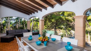 Une terrasse extérieure avec une table à manger, des chaises et un canapé.