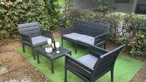 An outdoor seating area with a table and four chairs, a bottle, and two glasses. - Villa 'Casa Le Palme' with Sea View, Wi-Fi and Air Conditioning (GEREMEAS RESIDENCE)