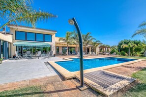 Une piscine avec une maison moderne en arrière-plan.