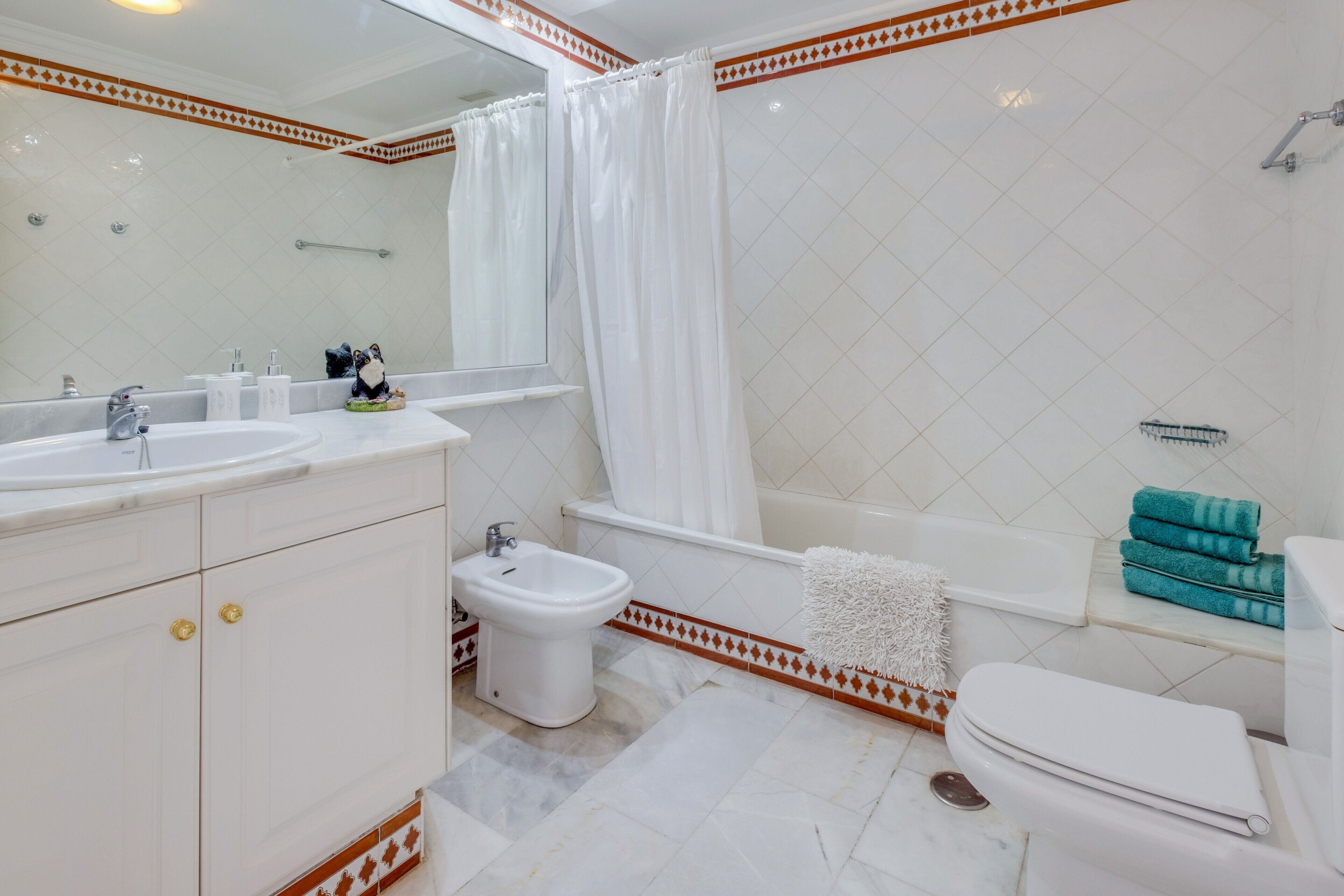 Ein Badezimmer mit Doppelwaschbecken, Bidet, Badewanne und Toilette.