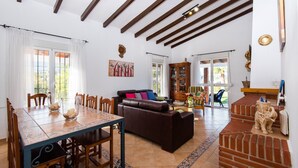 Un vaste espace de vie comprenant une table à manger, un canapé et un mur décoratif en briques.