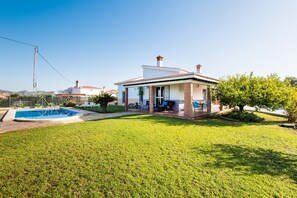 Une maison avec une piscine, un patio et une vue sur les environs.