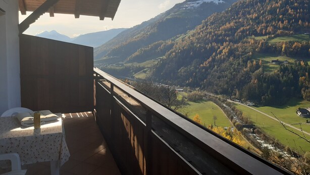 A balcony with a view of a valley, mountains, and a river. - Cosy Strickerhof Apartment 2 with Mountain View & Balcony (St. Leonhard in Passeier)