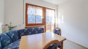 Un espace repas avec une table en bois et des sièges à motifs bleus.