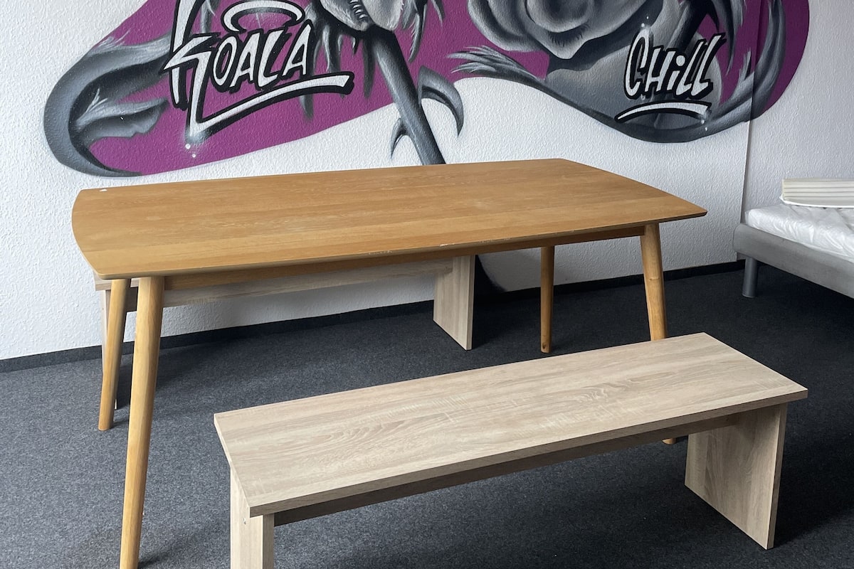 A room with a wooden bench and a wall mural featuring koalas and the words "Koala" and "Chill".