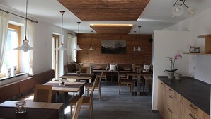 A modern interior with wooden ceiling, dining area, seating, and a kitchen counter. - Holiday Apartment 'Hofschenke Pfeiftal - Bergwiese' with Mountain View (St. Martin in Passeier)