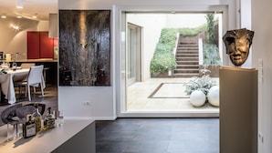 A modern interior with a dining area, a large abstract painting, and a sculpture. - Villa San Francesco - Homelike Villas (Assisi)