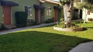 Uma fileira de casas com gramado bem cuidado e uma árvore no quintal.