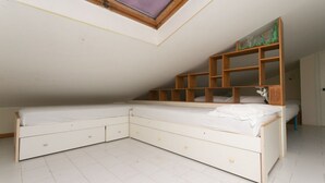 A bedroom with a loft bed, a skylight, and a built-in shelving unit. - M134 - Marcelli, four-room apartment with terrace 50 meters from the sea (Marcelli)