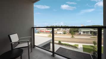 A balcony with a view of a parking lot and buildings.