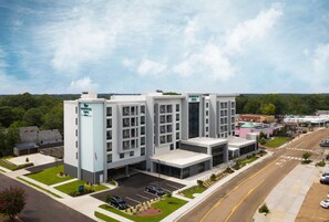 A multi-story hotel with a central courtyard, parking lot, and a view of the surrounding area. - Homewood Suites by Hilton Jackson Fondren Medical District (Jackson)