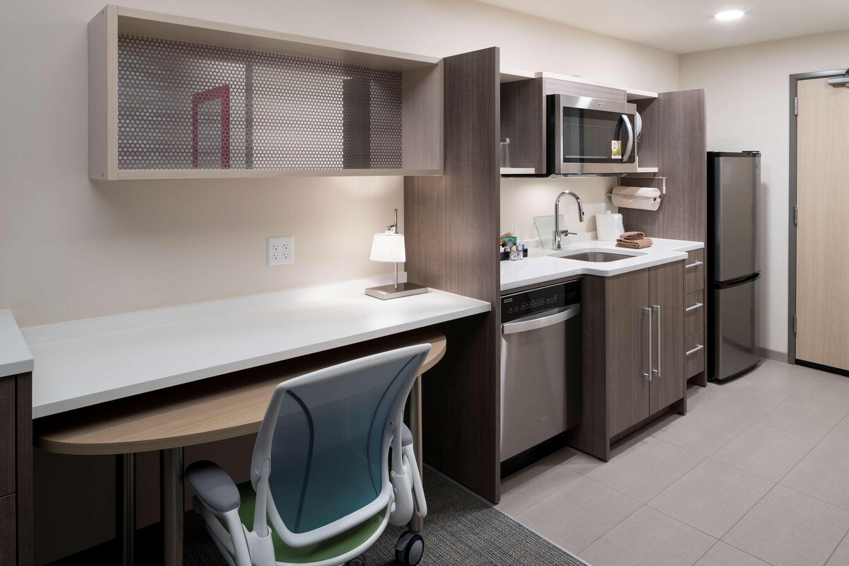 A modern kitchen with a built-in microwave, refrigerator, and dishwasher.