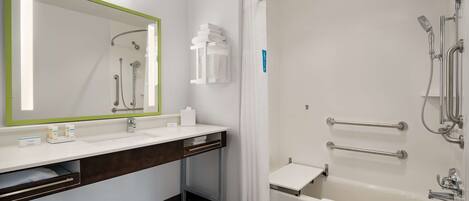 Une salle de bain moderne avec un grand miroir, un lavabo, une douche avec une porte en verre et une baignoire.
