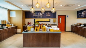 A breakfast bar with a sign reading "Happy Breakfast Starts Here" and a wall with "Let's Bake Memories" text. - Hampton Inn & Suites Imperial Beach San Diego (Imperial Beach)