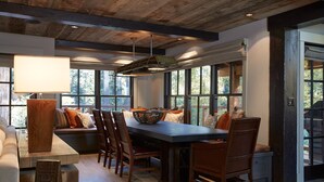 A modern kitchen with a large island, wooden chairs, and a built-in bench. - Stunning Private Compound with Hot Tub, Nearby Beach, Flat Lawn, at ski resort (Homewood)