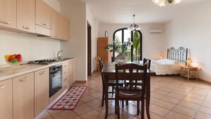 A kitchen with a dining area, a bed, and a view through a window. - Experience Italian flair up close - Monolocale 900 (Racale)
