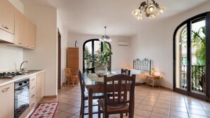 A modern kitchen with a dining area, a large window, and a chandelier. - Experience Italian flair up close - Monolocale 900 (Racale)